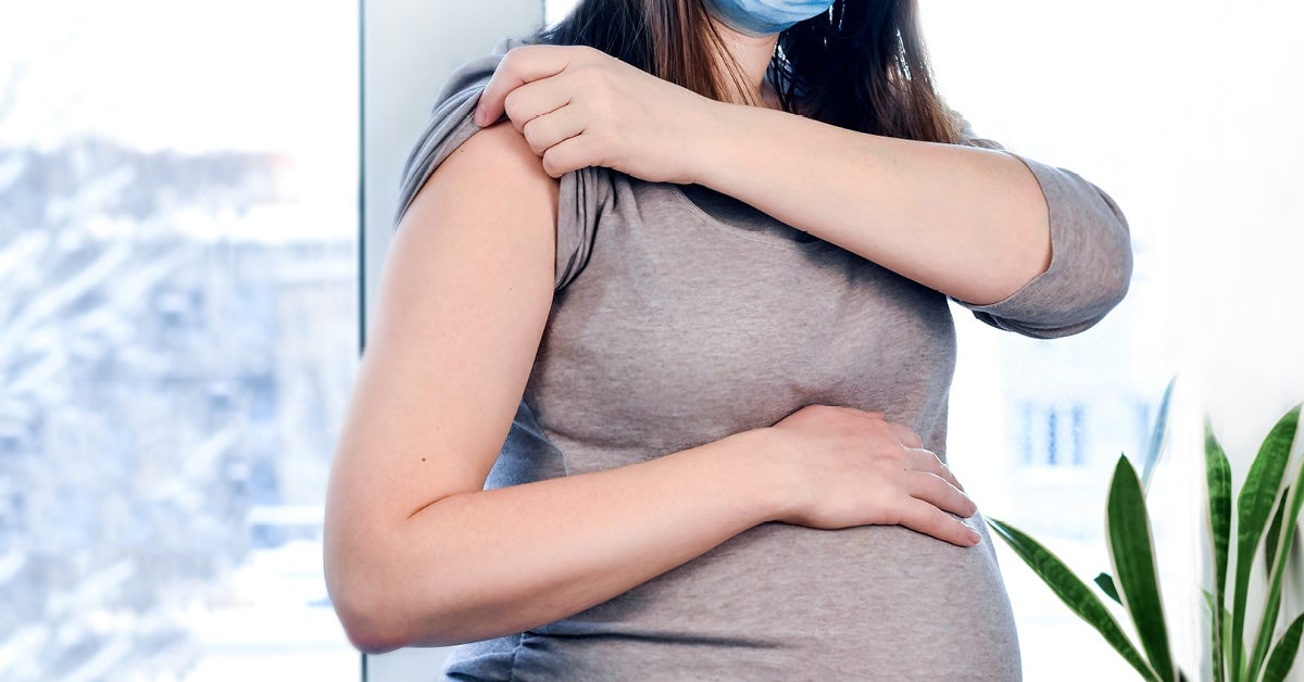 pregnant woman with her arm exposed for a vaccine shot