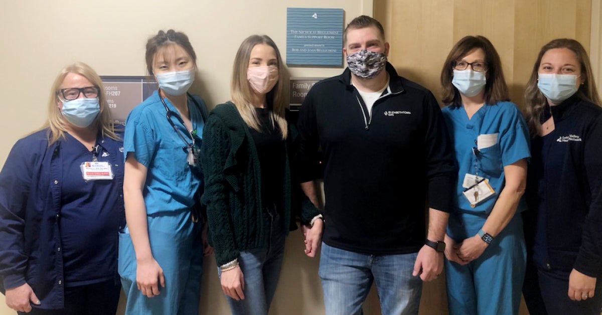 Kortney and Tyler Kemp pose with LVH–Muhlenberg NICU colleagues outside the Family Support Room.