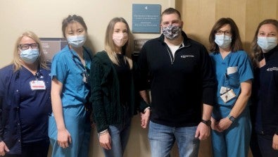 Kortney and Tyler Kemp pose with LVH–Muhlenberg NICU colleagues outside the Family Support Room.