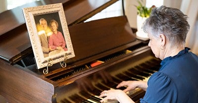 Joan Esgro, a cancer survivor, plays piano in her home
