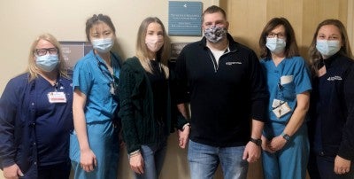Kortney and Tyler Kemp pose with LVH–Muhlenberg NICU colleagues outside the Family Support Room.